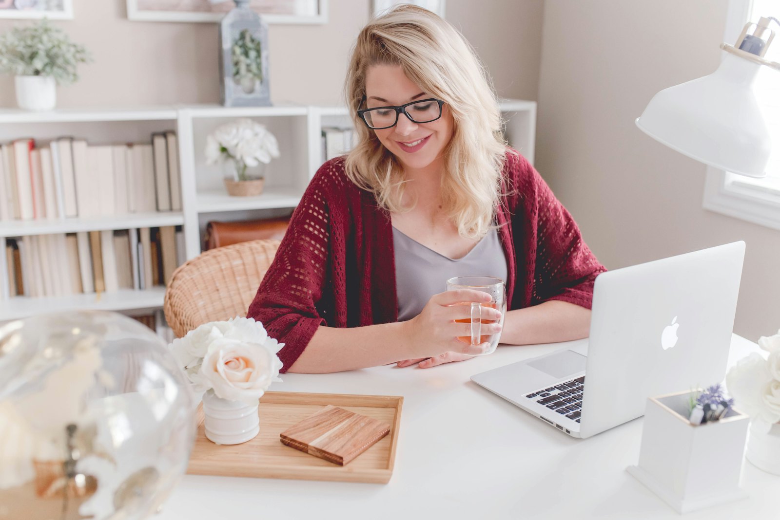 A smiling childcare director working at a laptop