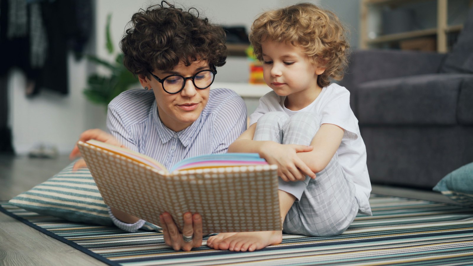 An adult and a child reading a book together